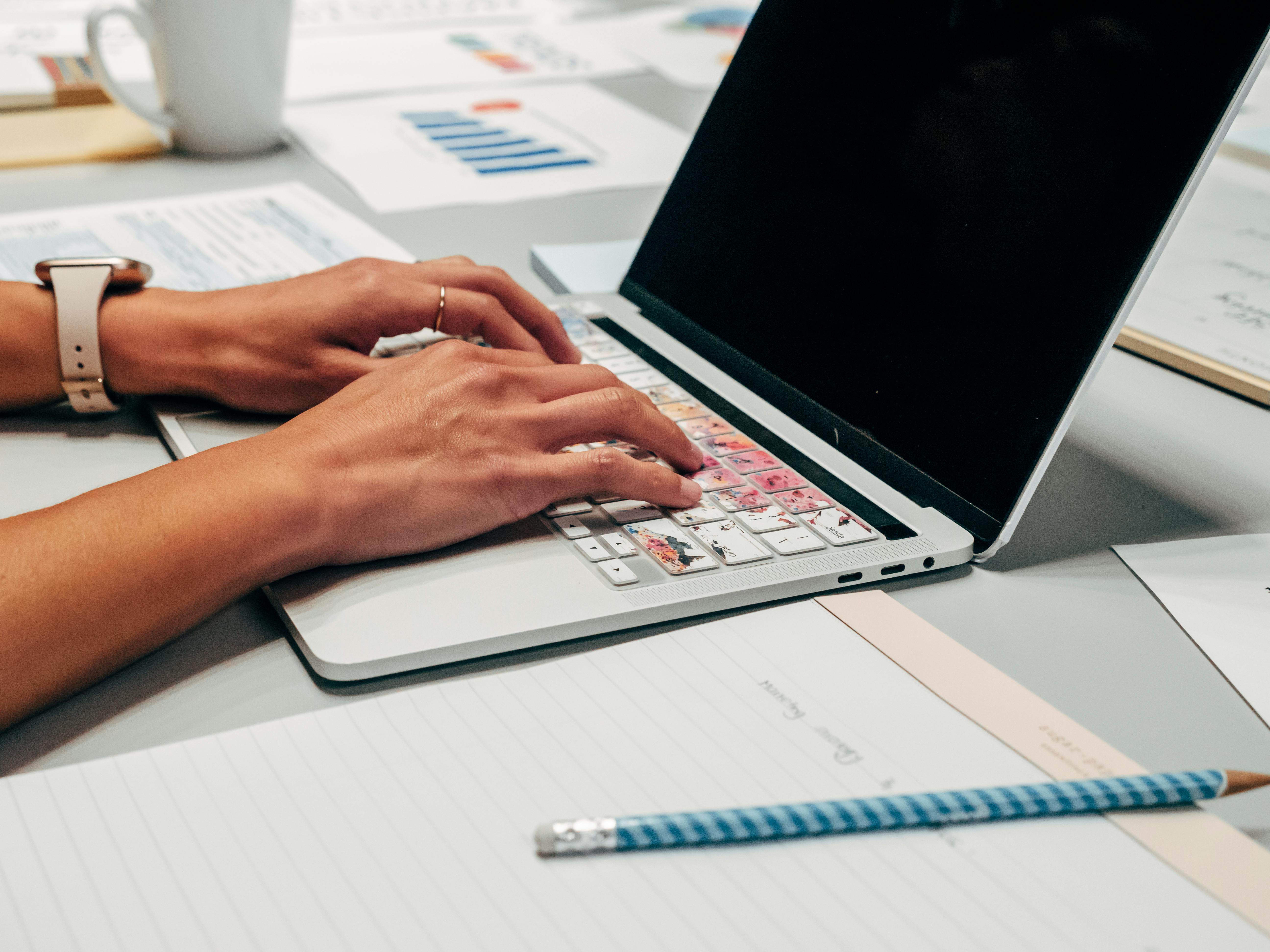 Laptop and person writing